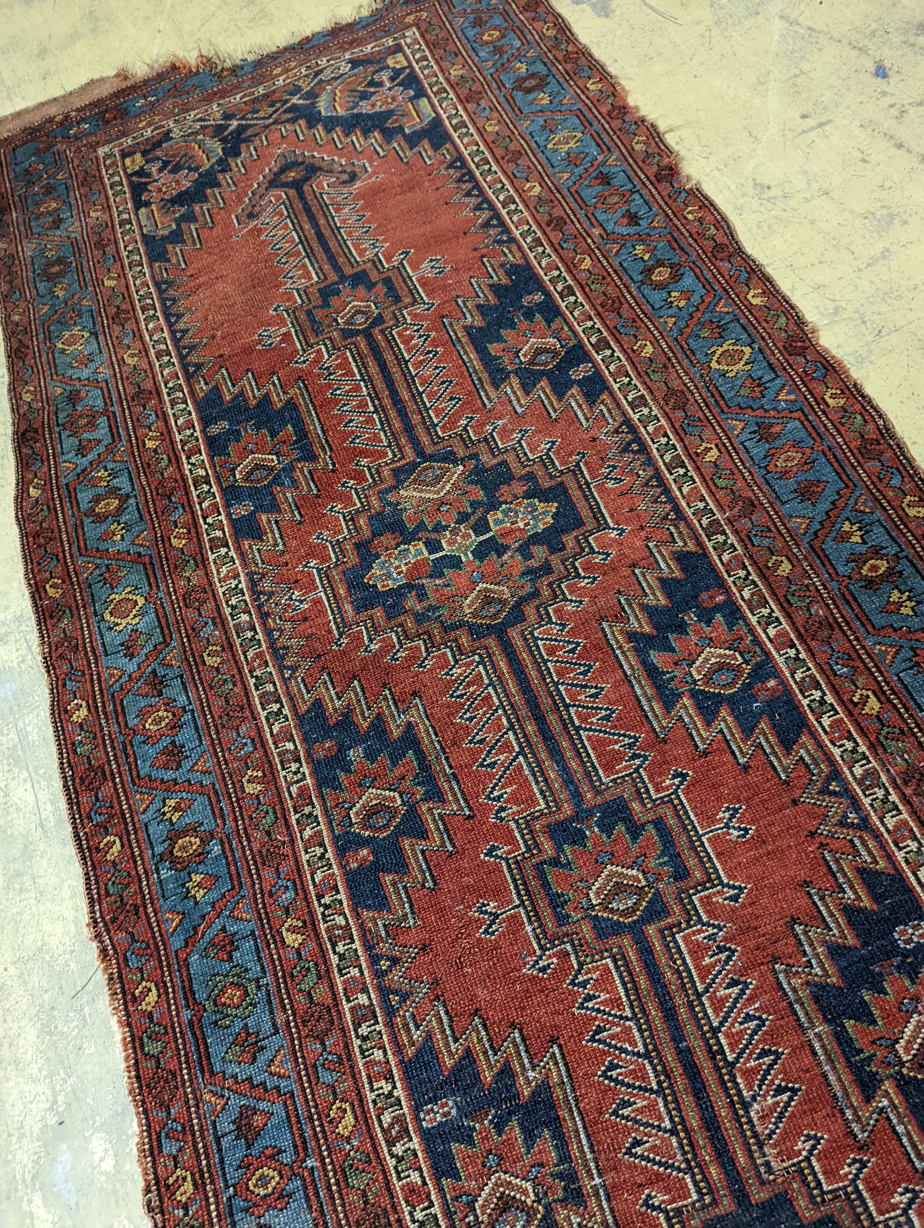 An antique Caucasian red ground runner, 380 x 100cm